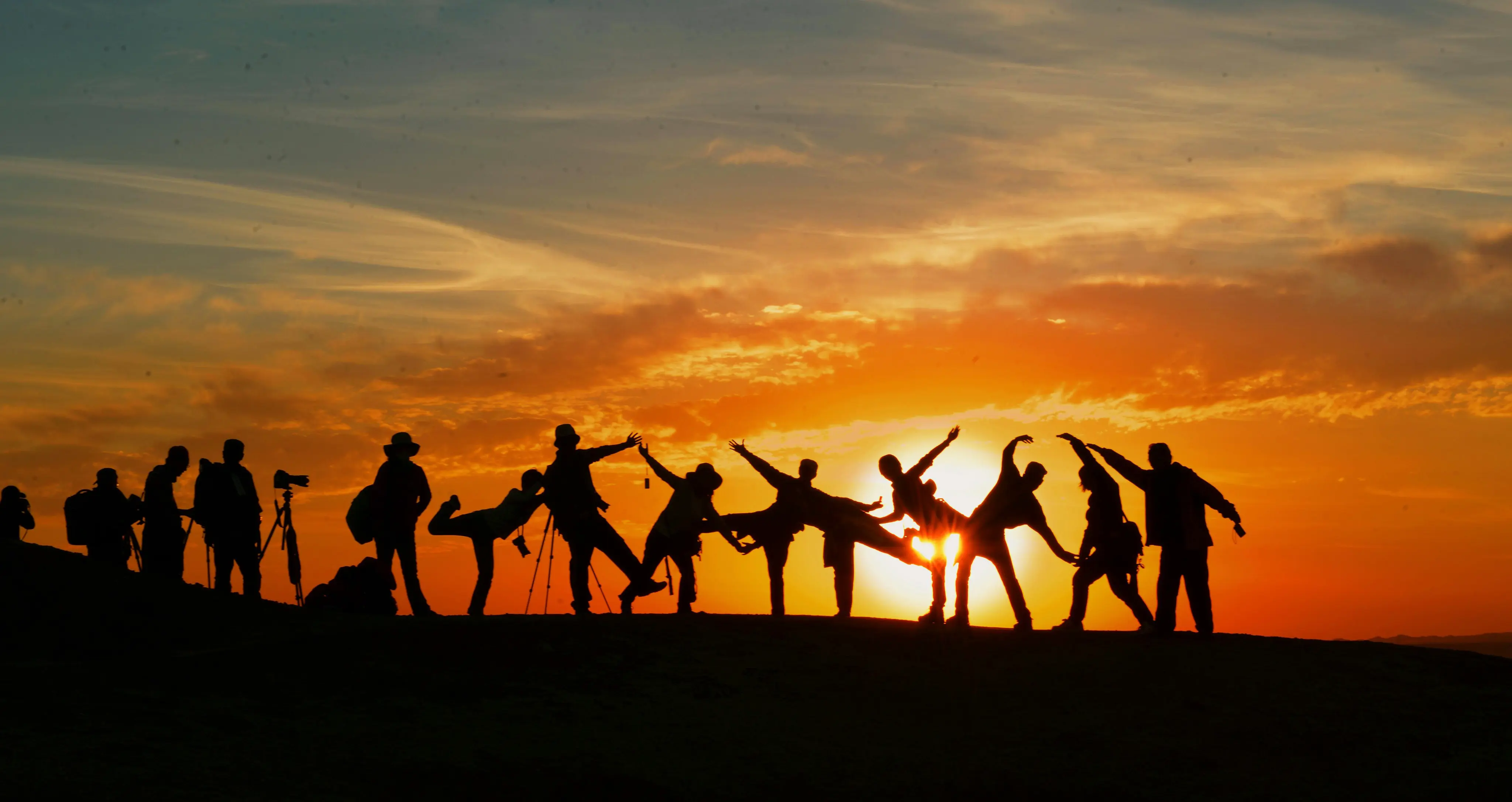 Silhouettes of a group of people posing at sunset